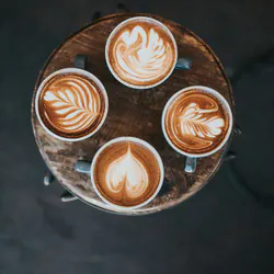 Tepsi üzerinde dört fincan latte, üstten çekilmiş